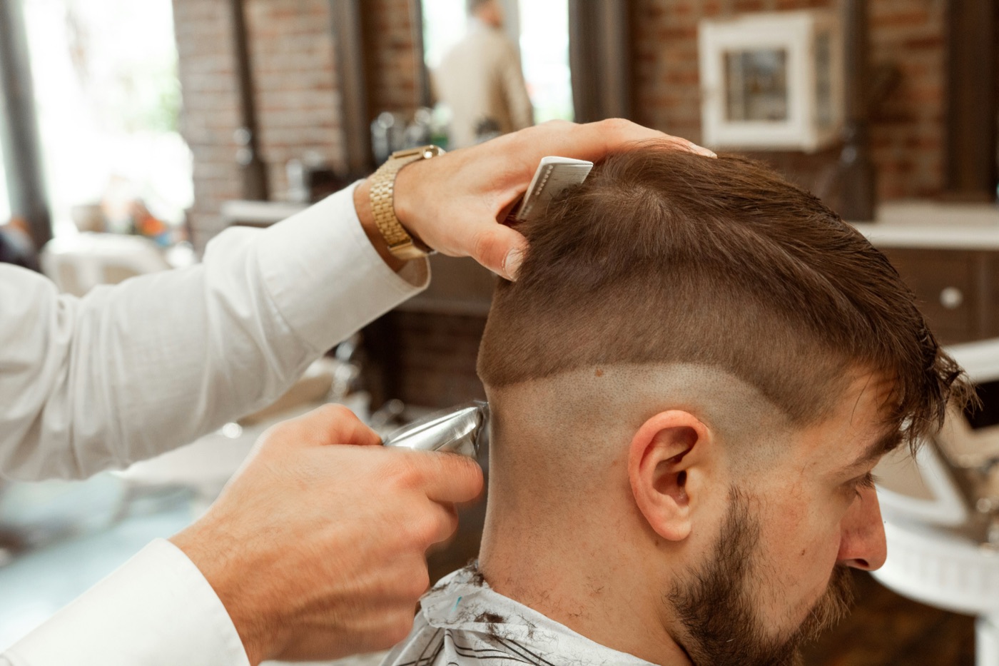 Barbier schneidet einen Fade mit der Maschine