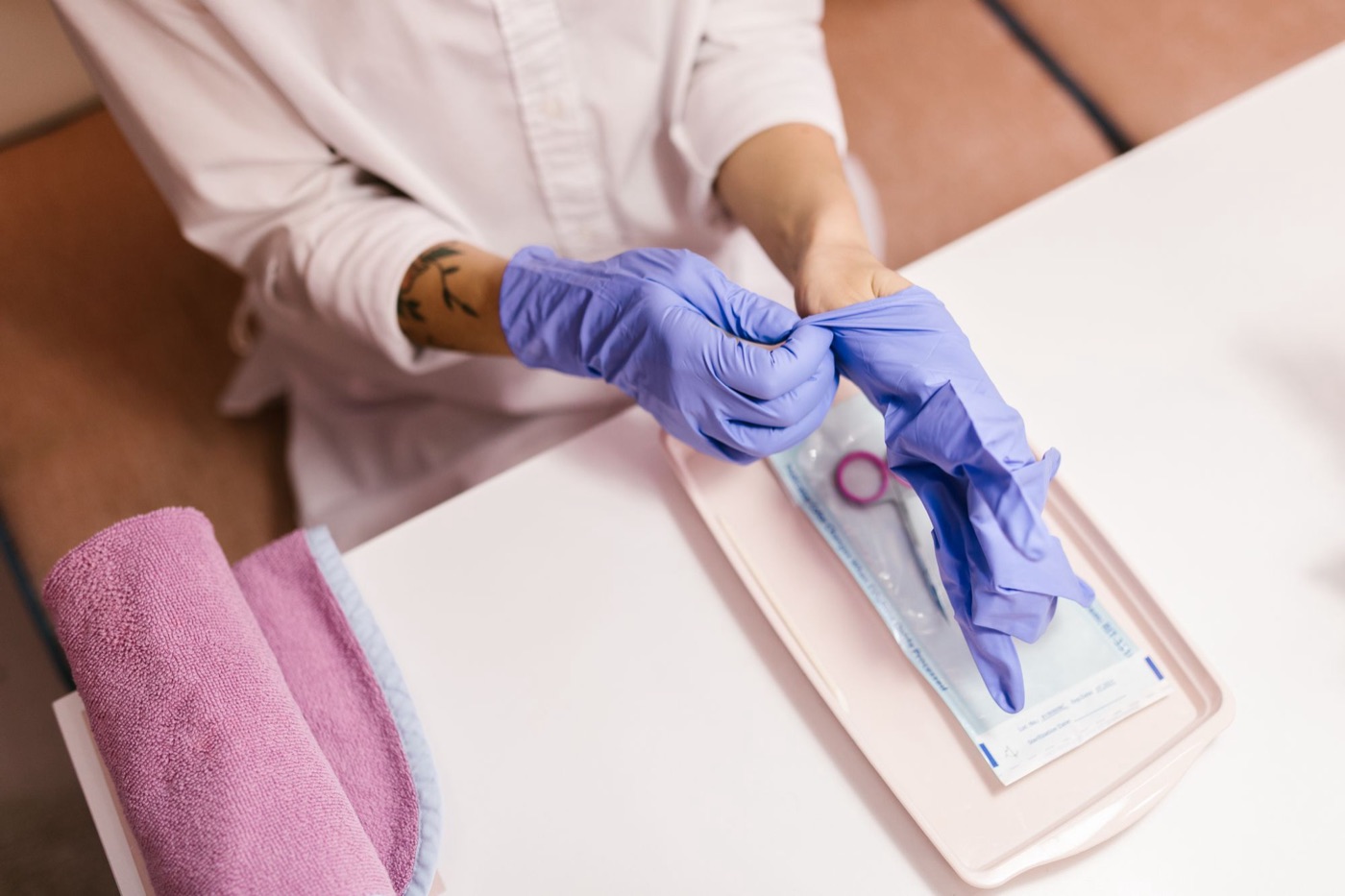 Nageldesignerin zieht Handschuhe an, Werkzeug liegt bereit