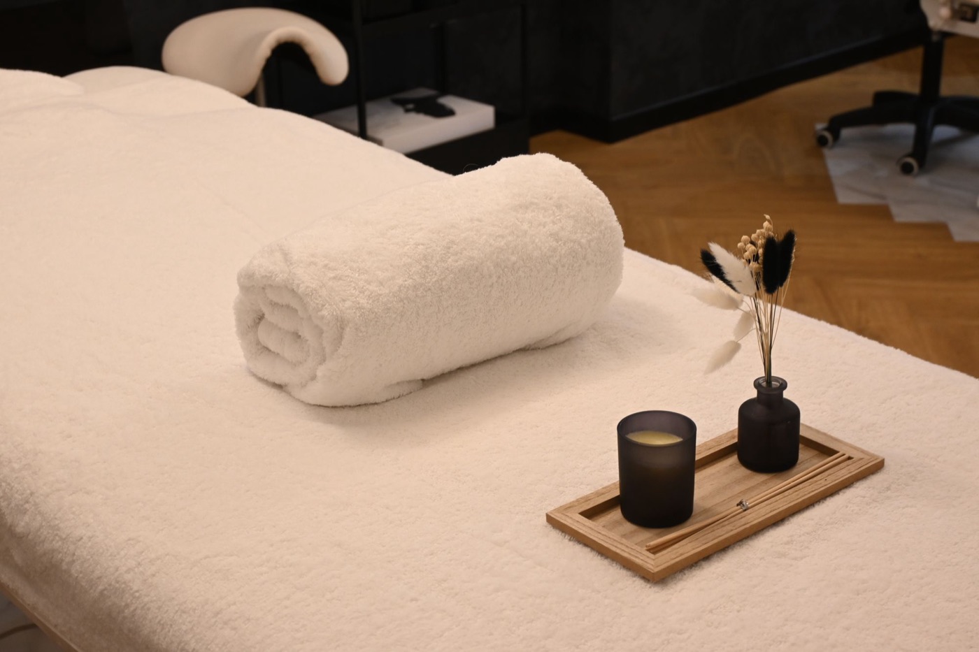 Vorbereitete Massageliege mit Handtuch und Kerze