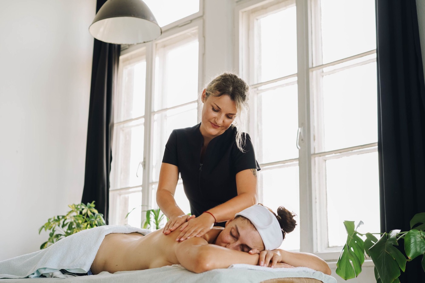 Masseurin massiert die Schultern einer Kundin