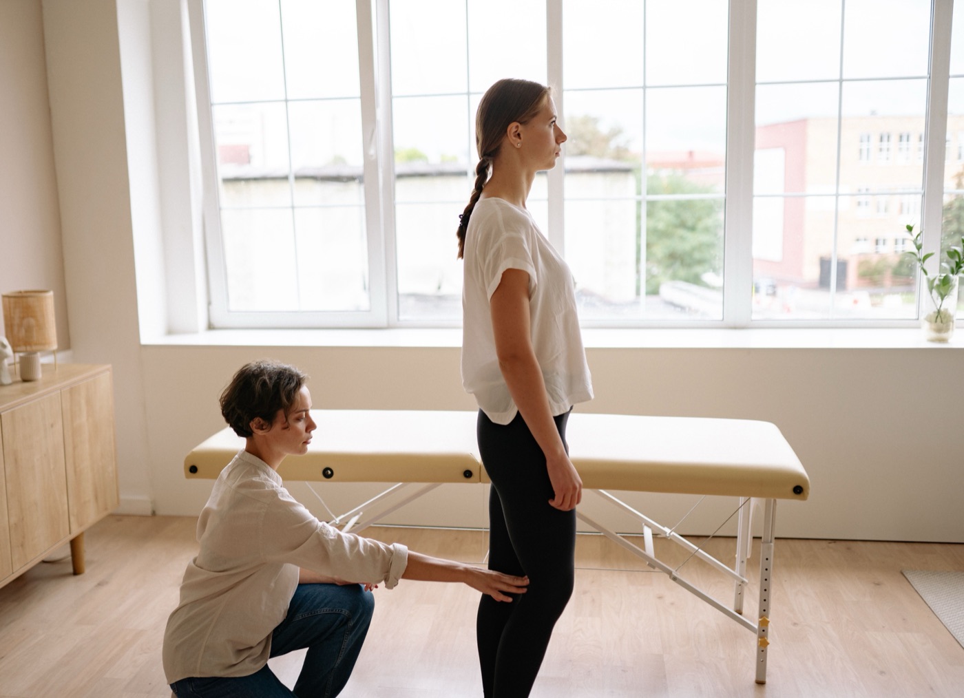 Physiotherapeutin prüft die Haltung einer Patientin