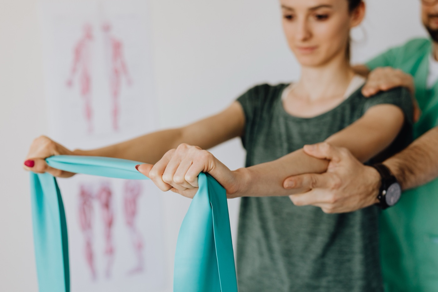 Übung mit dem Theraband, der Therapeut führt den Arm
