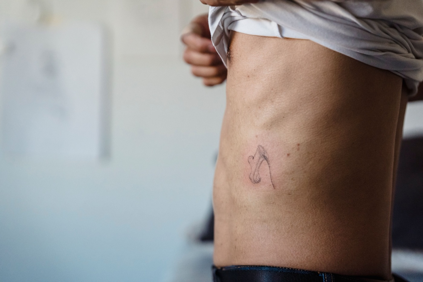 Frisch gestochenes Fineline-Tattoo an den Rippen